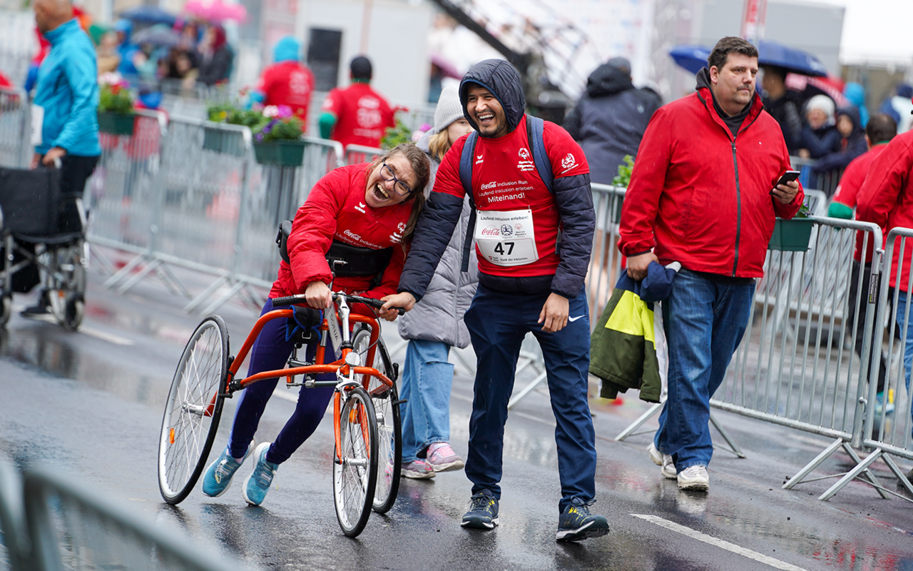 Eine Frame-Runnerin und ihr Begleiter auf der Strecke. Beide lachen.