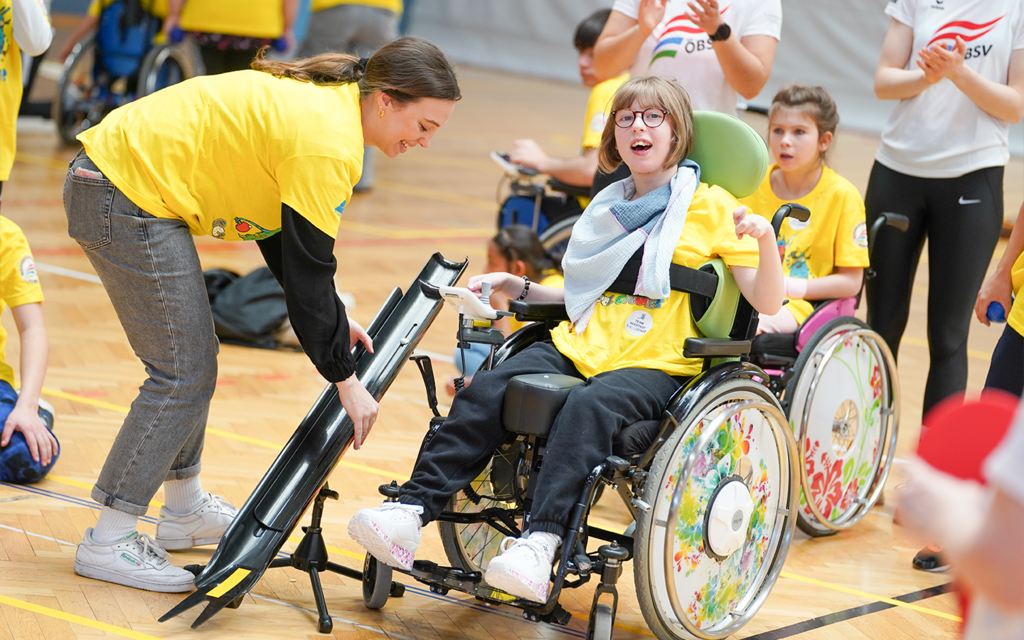 Eine junge Sportlerin freut sich über einen gelungenen Boccia-Wurf. 