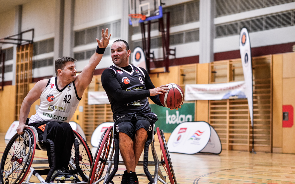 Zwei Rollstuhl-Basketballer kämpfen um den Ball.