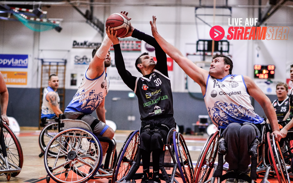 Ein Rollstuhl-Basketballer setzt zum Wurf an, während ein anderer versucht ihn daran zu hindern. 